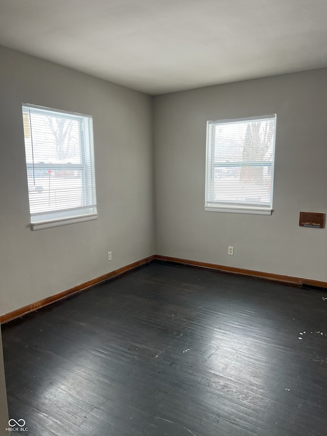 unfurnished room with dark hardwood / wood-style flooring