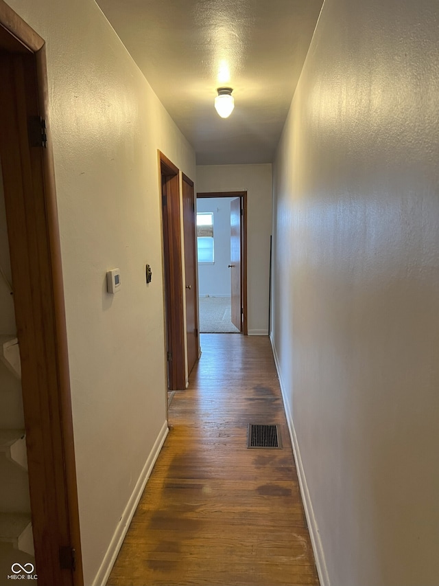 corridor featuring a textured ceiling and dark wood-type flooring