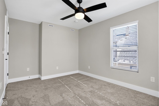 empty room with ceiling fan and light carpet