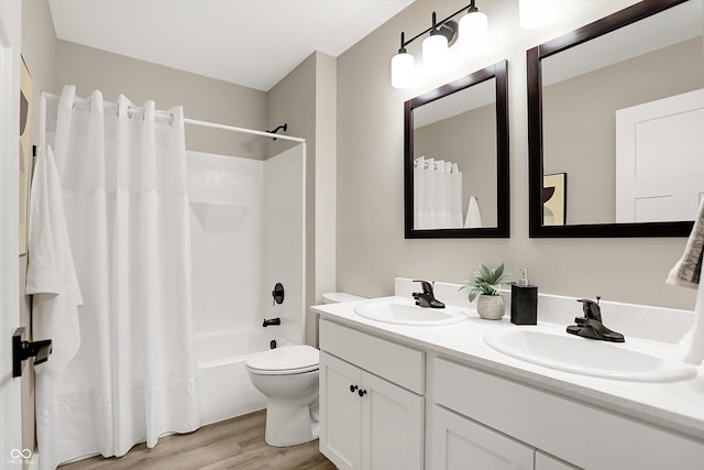 full bathroom with hardwood / wood-style floors, toilet, vanity, and shower / bath combo