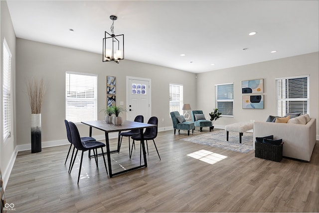 dining area featuring light wood-type flooring and a chandelier