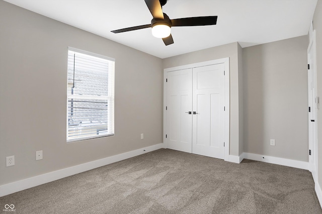 unfurnished bedroom with ceiling fan, a closet, and carpet