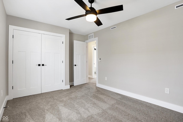 unfurnished bedroom with light colored carpet, ceiling fan, and a closet