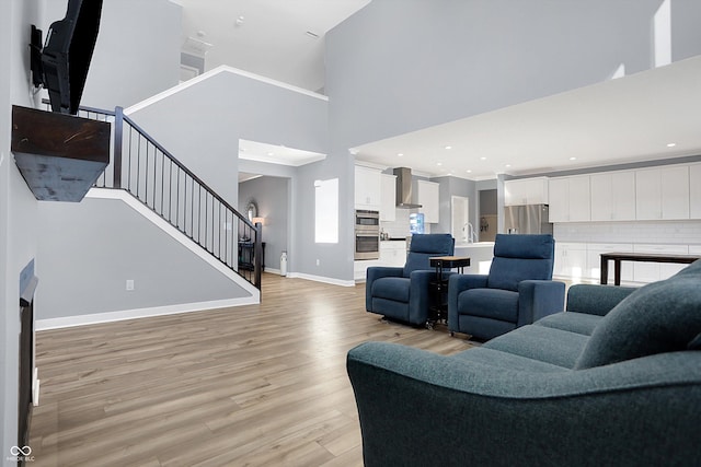 living room with a high ceiling and light hardwood / wood-style floors