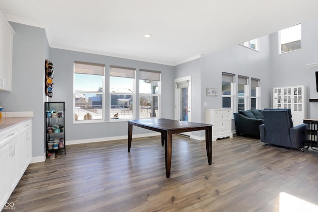 dining space with dark hardwood / wood-style flooring and ornamental molding