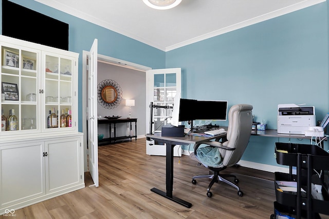 home office with crown molding and light hardwood / wood-style floors