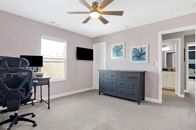 carpeted office space featuring ceiling fan