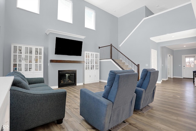 living room with a towering ceiling and hardwood / wood-style flooring