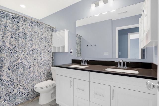 bathroom featuring toilet, vanity, and curtained shower