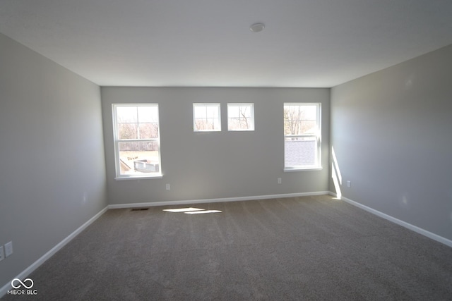 empty room with visible vents, baseboards, and carpet flooring