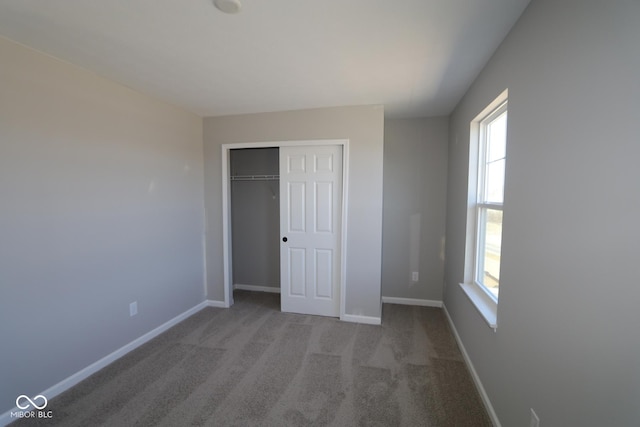 unfurnished bedroom featuring a closet, carpet, and baseboards