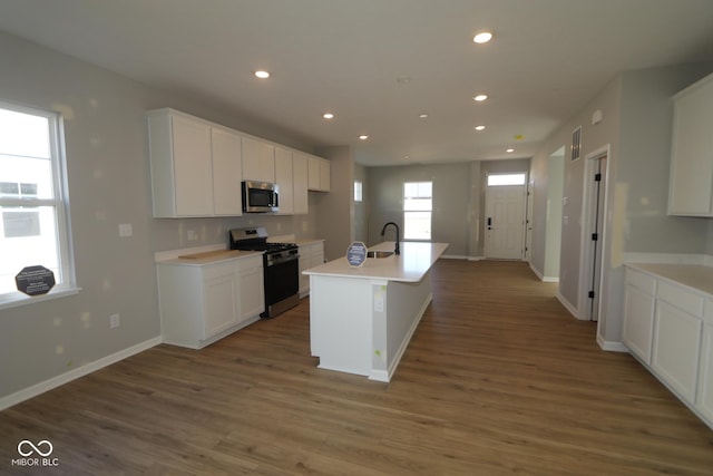 kitchen with visible vents, a sink, wood finished floors, white cabinetry, and stainless steel appliances