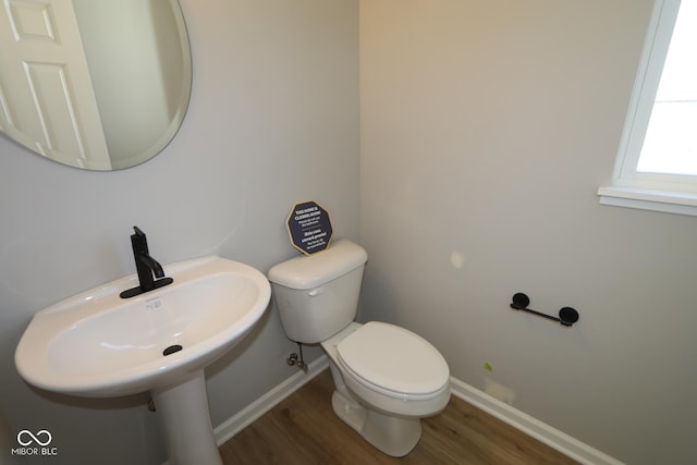 bathroom featuring a sink, toilet, baseboards, and wood finished floors