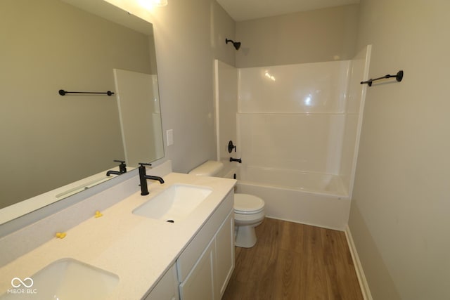 full bath with double vanity, toilet, wood finished floors, and a sink