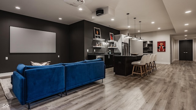 home theater with bar area and light hardwood / wood-style floors