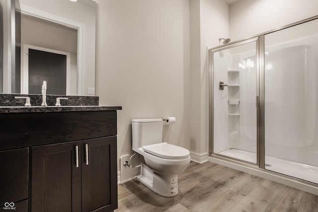 bathroom featuring vanity, toilet, wood-type flooring, and an enclosed shower