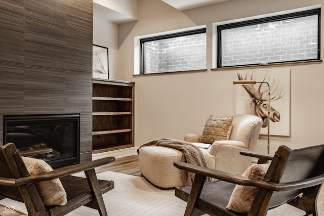 living area with a tiled fireplace and light hardwood / wood-style floors