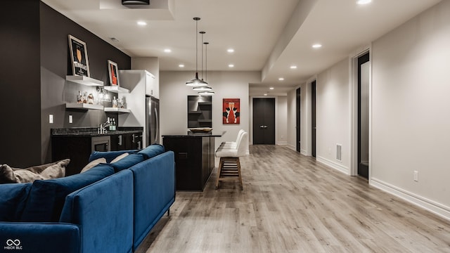 living room with bar and light hardwood / wood-style floors