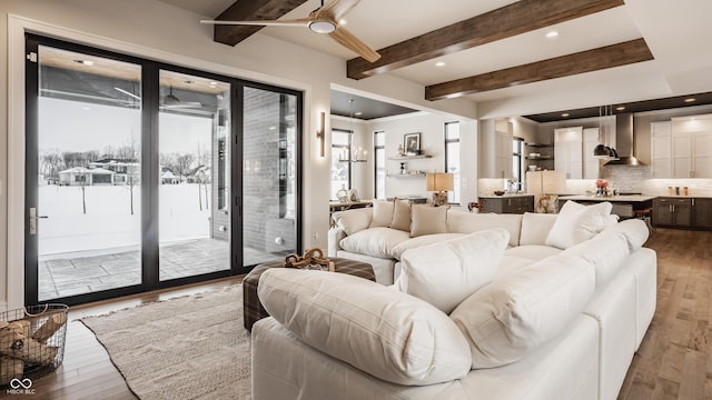 living room with ceiling fan, beam ceiling, and hardwood / wood-style flooring