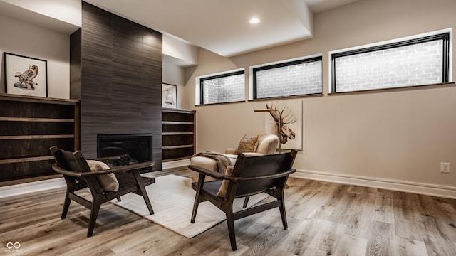 sitting room with light hardwood / wood-style flooring and a tiled fireplace