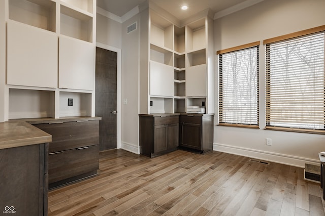 interior space featuring crown molding and light hardwood / wood-style floors