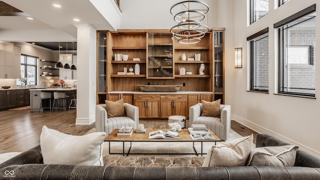 living room featuring hardwood / wood-style flooring, sink, and a notable chandelier