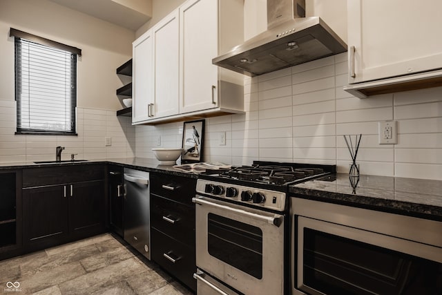 kitchen featuring stainless steel appliances, wall chimney exhaust hood, white cabinetry, and sink