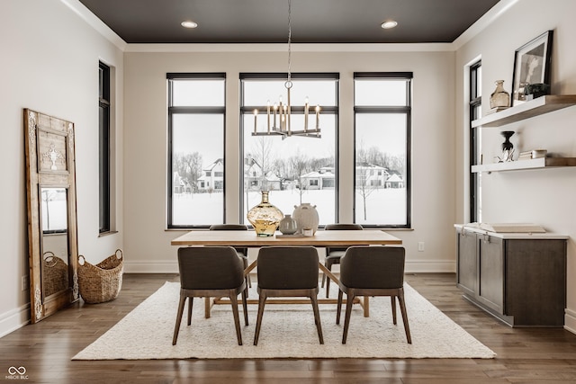 dining room with wood-type flooring, a notable chandelier, a wealth of natural light, and crown molding