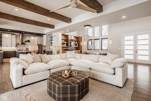 living room with beam ceiling, ceiling fan, french doors, and hardwood / wood-style floors