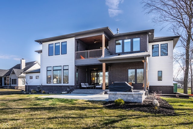 rear view of property featuring a patio area, a lawn, and a balcony