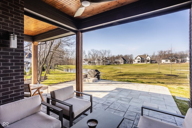 view of patio with ceiling fan and a water view