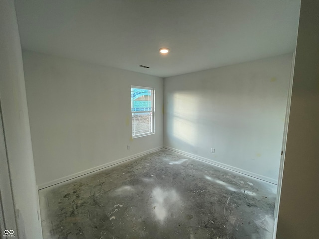 spare room featuring baseboards, visible vents, and unfinished concrete flooring