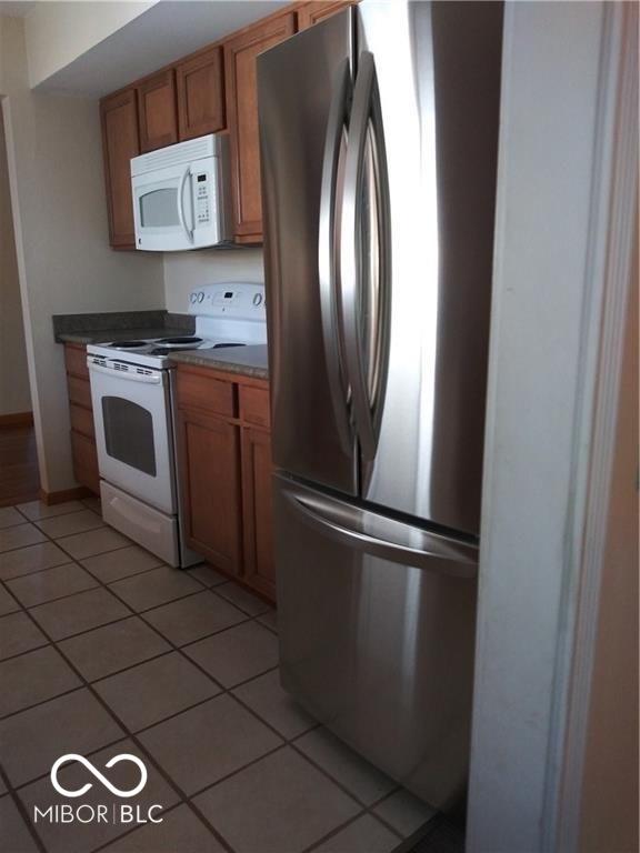 kitchen with white appliances and light tile patterned floors