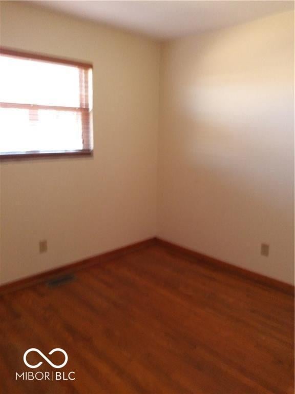 unfurnished room with hardwood / wood-style flooring