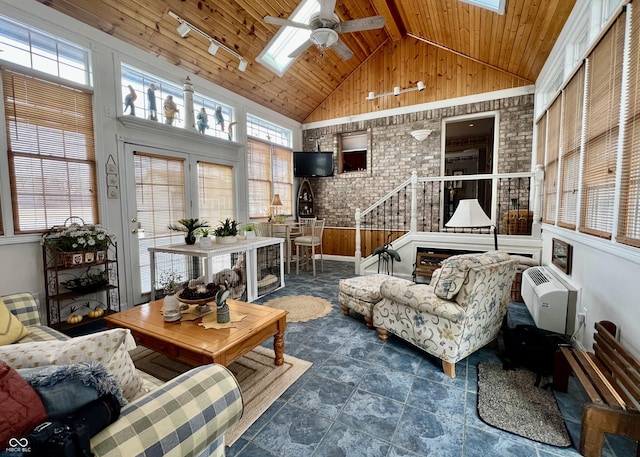 sunroom / solarium with lofted ceiling with skylight, a wall mounted air conditioner, rail lighting, ceiling fan, and wooden ceiling