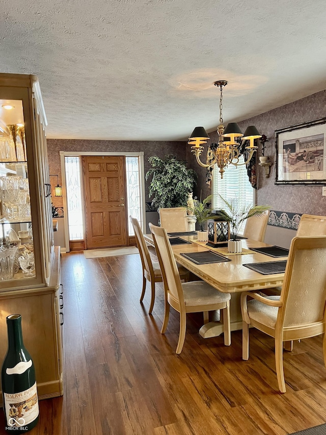 dining space featuring dark wood-type flooring and a notable chandelier