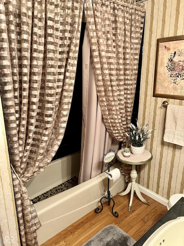 bathroom with wood-type flooring and shower / bathtub combination with curtain