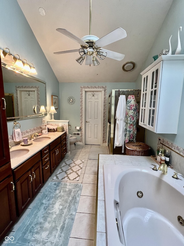 full bathroom with lofted ceiling, vanity, ceiling fan, toilet, and tile patterned floors