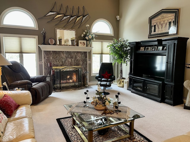 living room featuring a high end fireplace, a high ceiling, and carpet