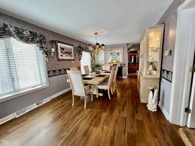 dining room featuring dark wood-type flooring and a notable chandelier