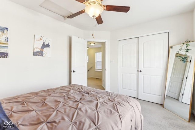 bedroom with a closet, ceiling fan, and light colored carpet