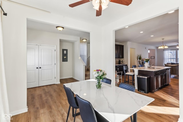 dining area with sink, an inviting chandelier, and hardwood / wood-style flooring