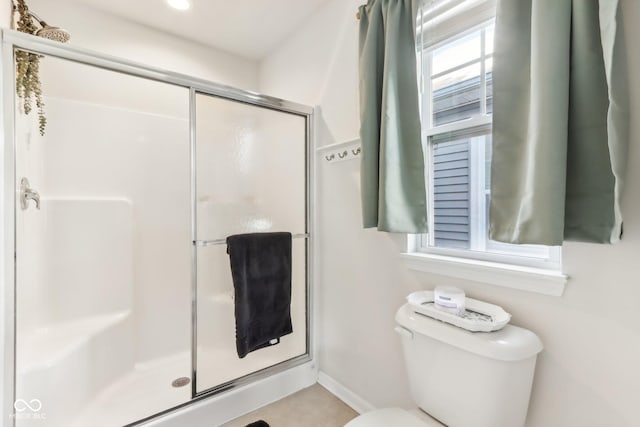 bathroom with an enclosed shower and toilet