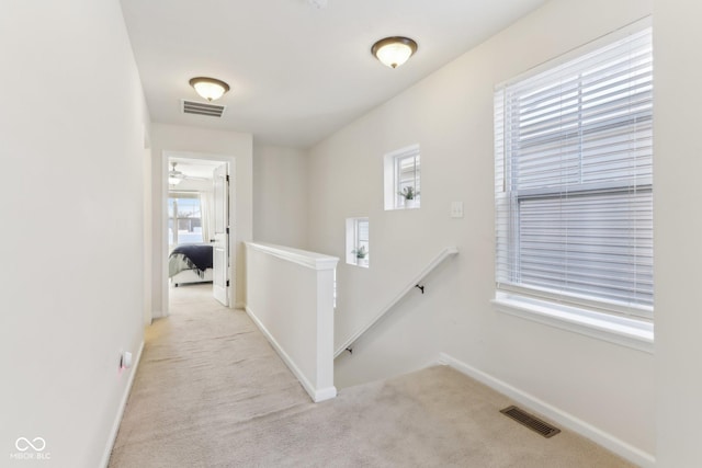 corridor featuring light colored carpet