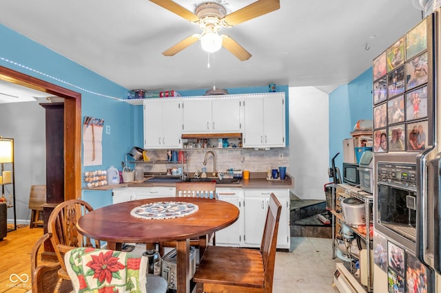 kitchen featuring ceiling fan, white cabinets, backsplash, and sink