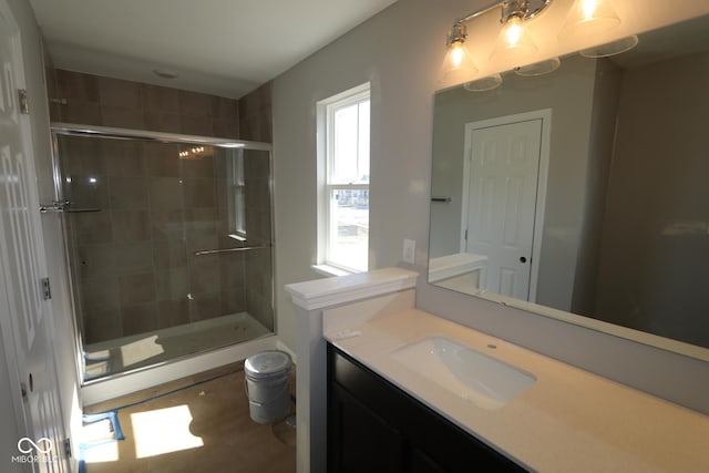 bathroom with a shower stall, vanity, and toilet