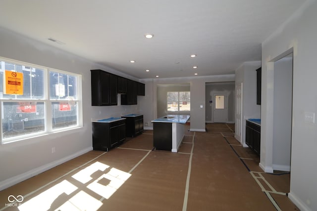 kitchen featuring visible vents, baseboards, a kitchen island, recessed lighting, and light countertops