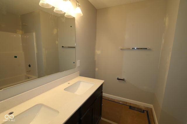 bathroom featuring double vanity, visible vents, baseboards, and a sink