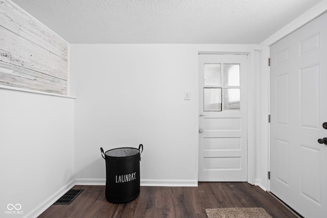 interior space featuring a textured ceiling and dark hardwood / wood-style floors