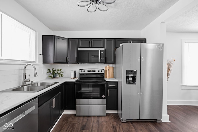 kitchen featuring decorative backsplash, dark hardwood / wood-style flooring, sink, and stainless steel appliances